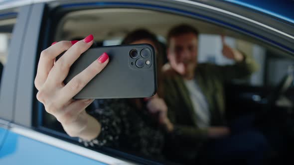 A Young Couple Takes a Selfie in a New Car They Bought at a Dealership alt