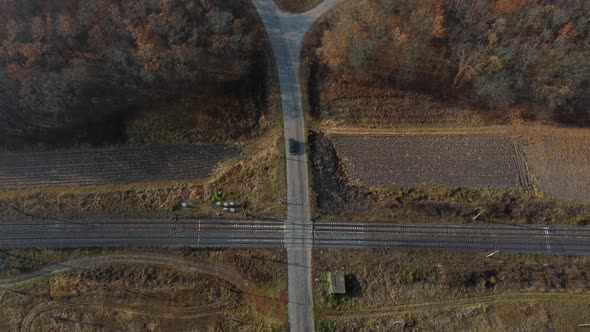 Panoramic View of Railroad Crossing Between Trees in Fields Aerial Drone View alt