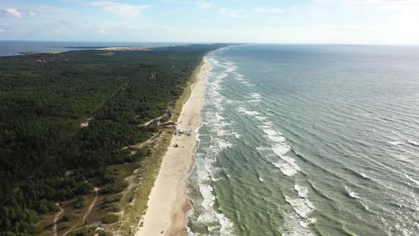 AERIAL: Flying Backwards Above Majestic Nida Beach with Forest and Sea 