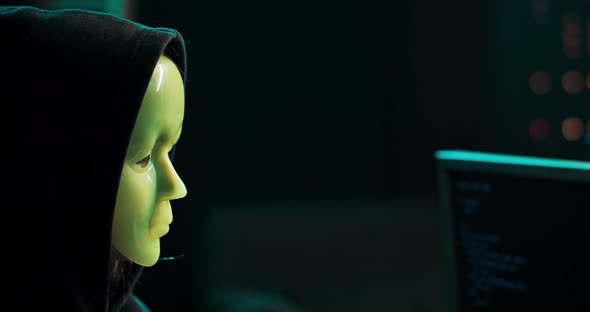 Closeup Shot of Masked Anonymous Hacker Organizes Malware Attack on Global Scale Dangerous alt