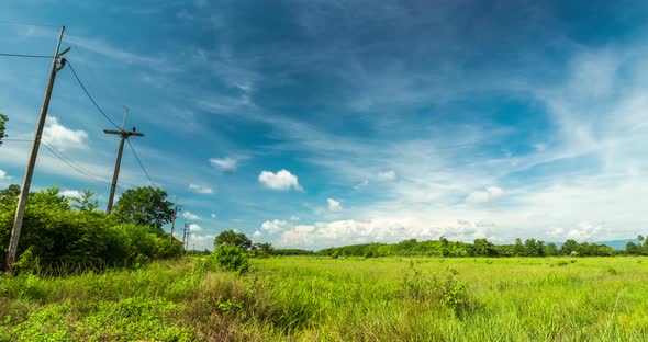 Passing Clouds Over Grassland With Row Of Electric Pole Along The Street