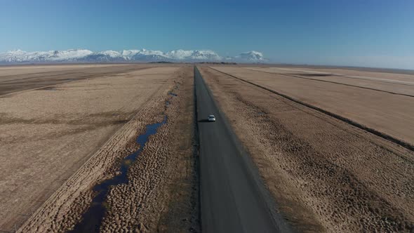 Aerial View of a Moving Car on a Deserted Road in Iceland in Early Spring