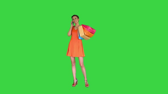 Young Woman Holding Shopping and Making a Phone Call on a Green Screen, Chroma Key alt