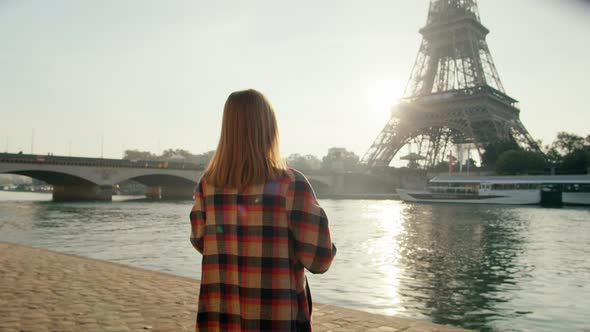 Back View of Woman Taking Picture By Smartphone of Eiffel Tower in Paris France