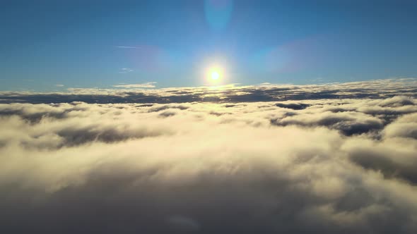Aerial View From Above at High Altitude of Dense Puffy Cumulus Clouds Flying in Evening alt
