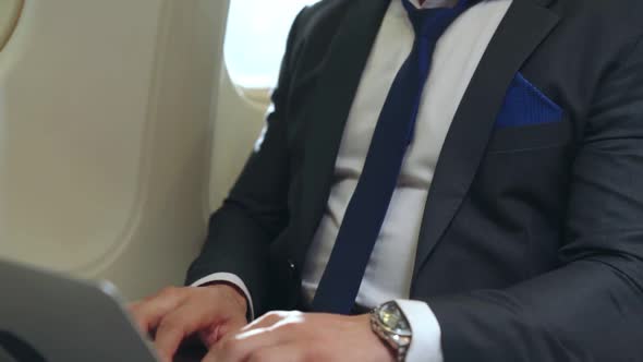 Young Businessman Using Laptop Computer in Airplane alt
