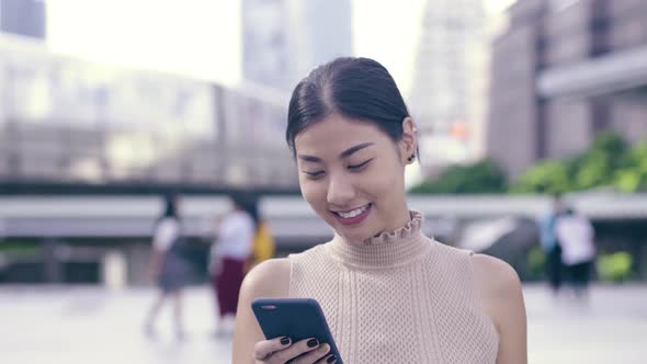 Asian Girl Using Smartphone At City
