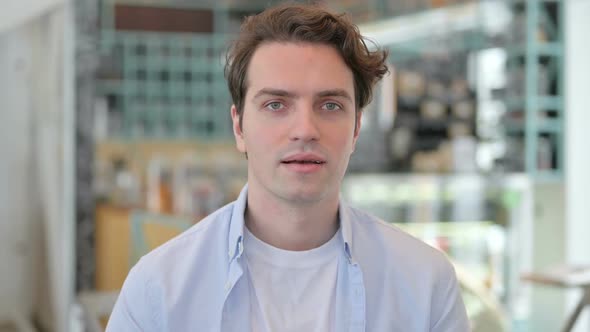 Portrait of Creative Man Showing Thumbs Up Sign alt