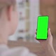 Rear View of Woman Looking at Smartphone with Green Chroma Screen