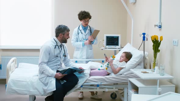 Female doctor patting on the head little kid