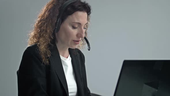 Customer Support Agent or Call Center with Headset Works on Desktop Computer While Supporting the alt