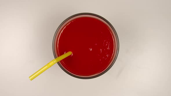 Drinking a fresh tomato juice by a straw