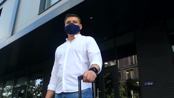Low angle view of tourist businessman in protective mask in the city. COVID-19