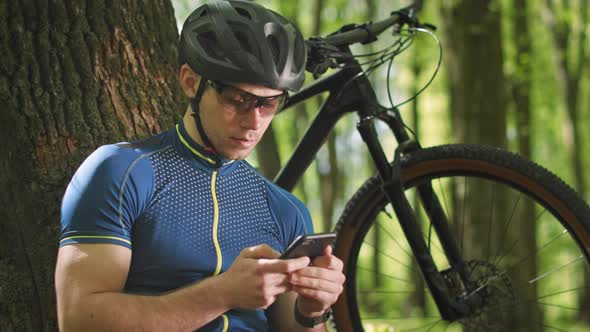 A Cyclist is Viewing Training Analytics on a Smartphone alt