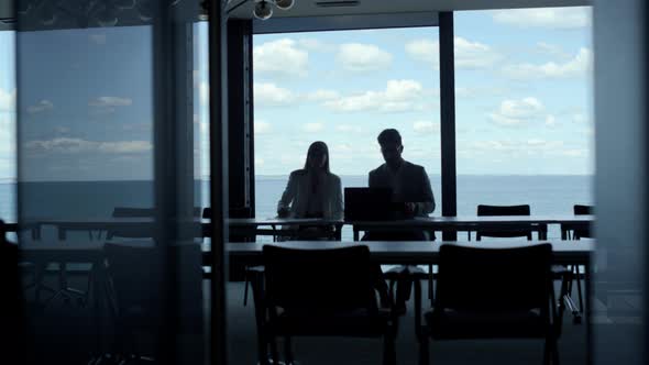 Business Team Silhouettes Talking at Sea Clouds View alt
