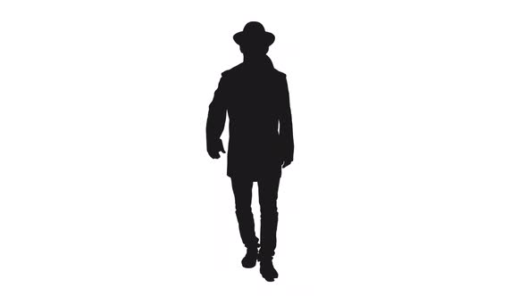 Silhouette Of Stylish Man In Coat and Hat Walking Towards the Camera