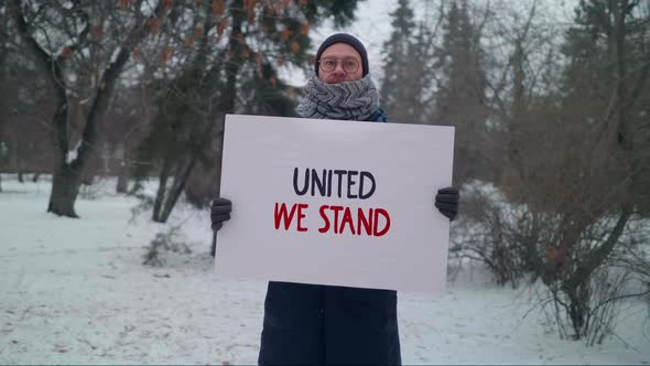 Man In Winter Park Holds Banner With United We Stand Motto Encouraging Unity alt