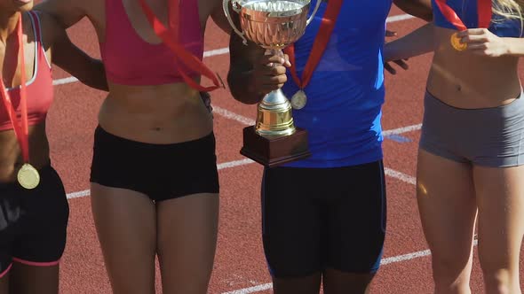 Team of athletes jumping and rejoicing winning many awards in competition alt