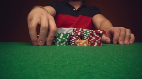 Male Player Moving Casino Chips on Poker Table Close Up