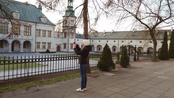 Girl Tourist Makes a Photo of Palace in the Old Square