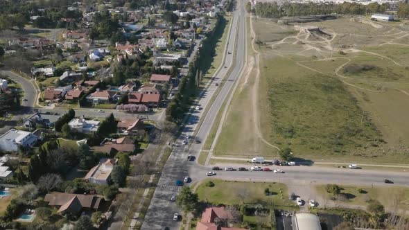 Aerial Drone shot of highway with cars going through and suburbs on side alt