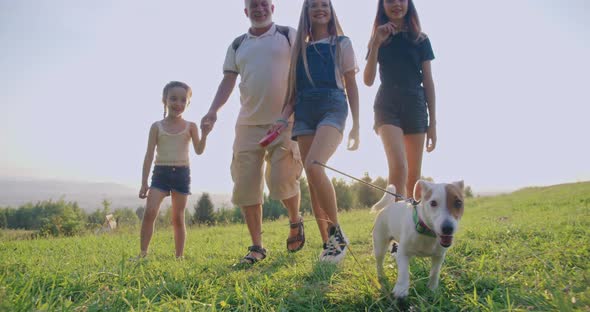 Father with Daughters and Dog Walking Along Field in Countryside alt