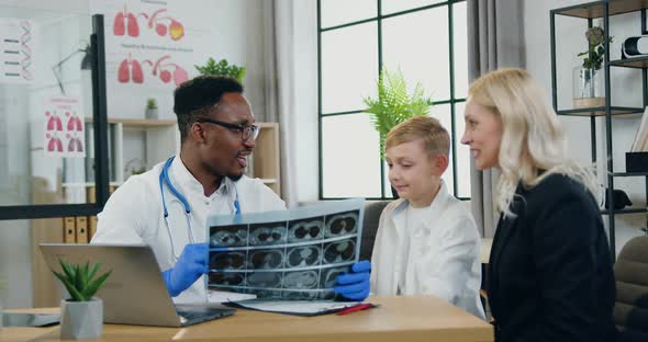 Doctor is Satisfied from X-ray Image of His Boy-Patient and Giving High Five Each other alt