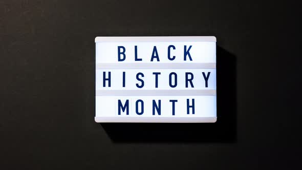Lightbox with text BLACK HISTORY MONTH on dark background with mirror reflection. 4k alt