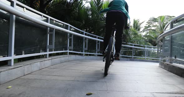 Woman riding bike at city on sunny day alt