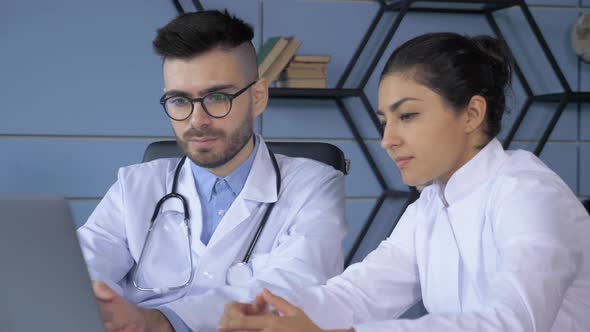 Close-up of Two doctors, a Man and a Woman, Discussing the Breakdown, Working