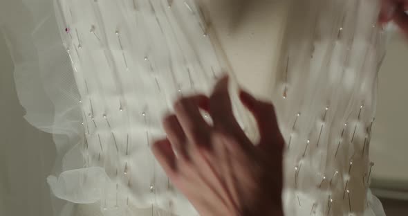 seamstress attaches pins corset wedding dress manikin showing outline incision alt