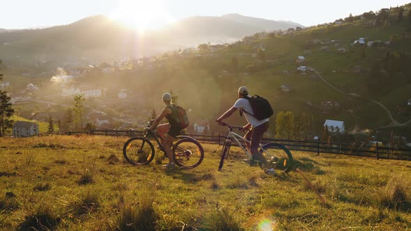 Family Couple of Cyclists Riding in the Mountains alt