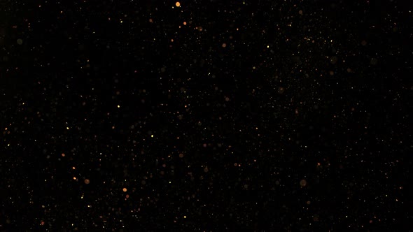 Super Slow Motion Shot of Golden Glitter Background Isolated on Black at 1000 Fps alt