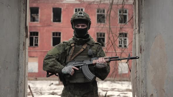 Portrait of Professional Fully Equipped Soldier with Kalashnikov Assault Rifle Looking Into the
