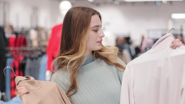 Caucasian Pensive Thoughtful Stylish Girl Woman Female Client Buyer Customer Stand in Clothing Store alt