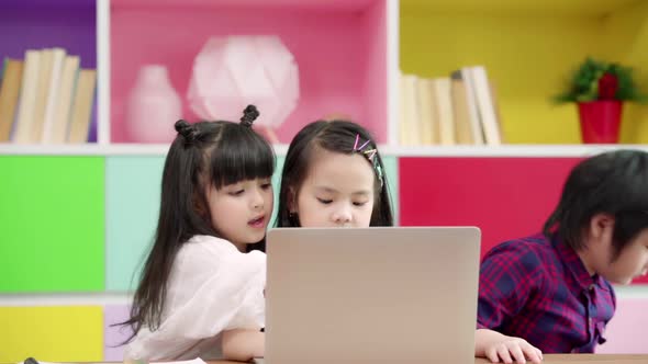 Multi-ethnic young boys and girls happy using technology for study at elementary school. alt