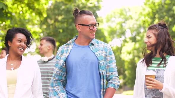 International Friends with Coffee Walking in Park  alt