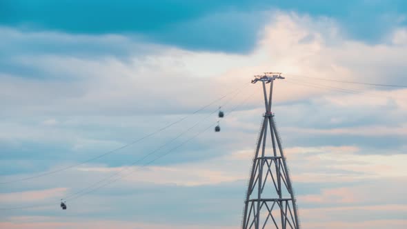 Timelapse, Fast Moving Gondola Lift Cable Car System Against Cloudy Sunset Sky alt