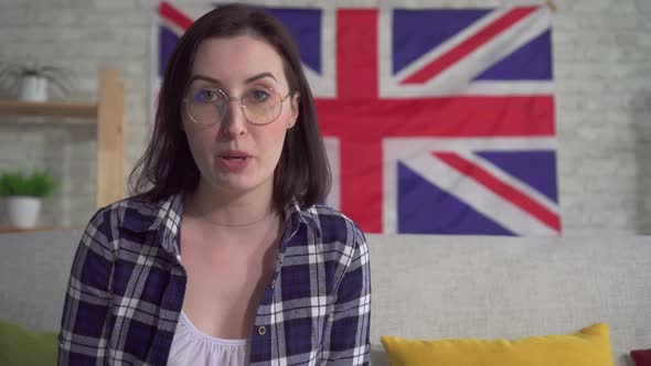 Young Woman Blogger in Shirt on the Background of the Flag UK Entry Video Close Up alt