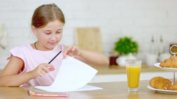 Girl Draws While Sitting in the Kitchen alt