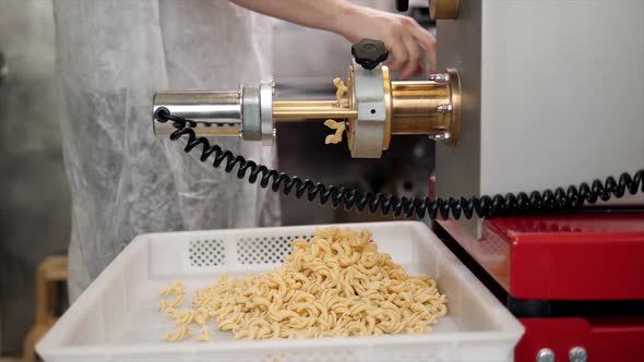 Tortiglioni Cazarece Spaghetti Pasta Falling From a Spout As They Travel Along the Production Line alt