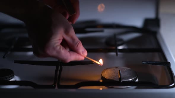 Lack of gas. A man is trying to light a match with gas on a gas stove alt