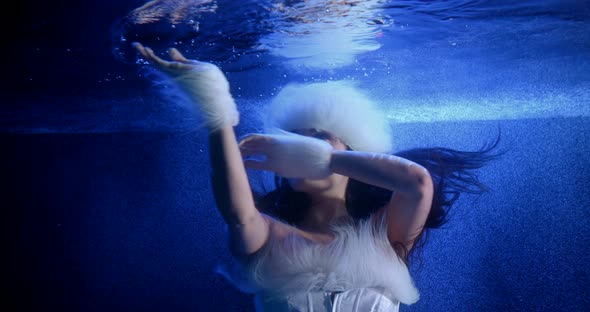 a Cute Brunette with Long Hair in a White Dress with White Fur and a White Fur Hat Is Floating alt