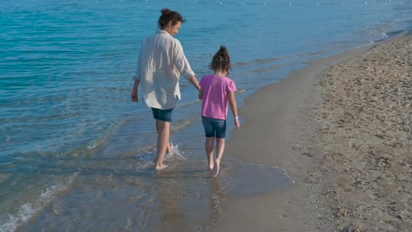 Family walks on the beach.  alt
