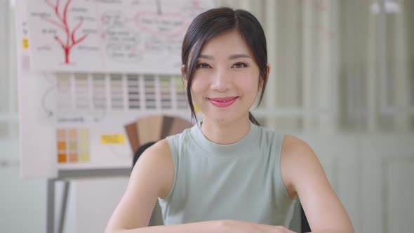 Close up portrait young Asian woman smiling in office