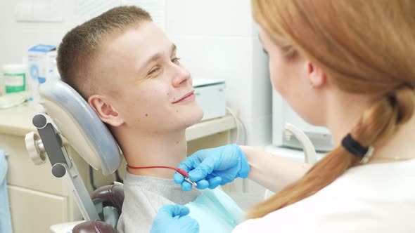 Caring Doctor Reassures Client Dentist in Clinic is Beautiful Woman