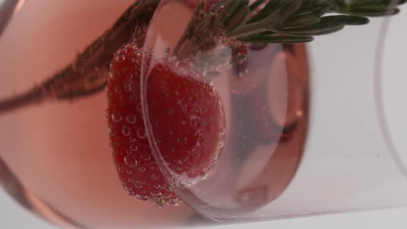 Vertical video, Close-up: lemon fells in a glass of bubbling champagne with cucumber alt