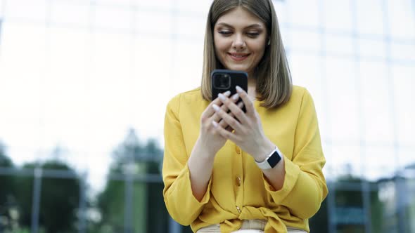 Happy Businesswoman Using Mobile Phone Smartphone at Remote Workplace