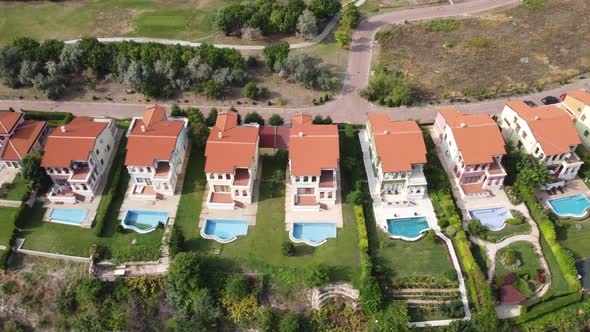 Modern Cottage Village with Luxury Houses Swimming Pools and Golf Courses Aerial View alt