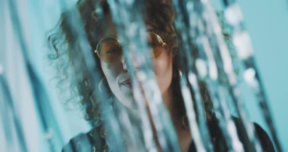 Woman wearing fun glasses dances alt